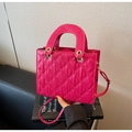 Détail d'un sac à main matelassé rose rouge avec poignée ronde et boucles dorées - Rose Rouge