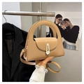 Detail of beige semi-circle handbag featuring a gold buckle and circular handle grip - Khaki