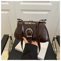 Close-up of vintage dark brown wax leather saddle bag with silver horseshoe buckle - Coffee