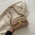 Elegant beige baguette underarm bag with gold metal U-clasp on minimalist blazer - Khaki