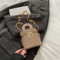 Sac seau beige avec chaîne dorée et double fermeture éclair sur un blazer noir - Kaki
