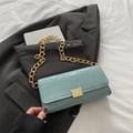 Mint green crocodile pattern baguette bag with a chunky gold chain strap on grey blazer - Lake Blue