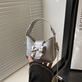 Metallic silver mini bow handbag with chain strap shown in a stylish studio setting - Silver