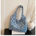 Detail of light blue tote bag featuring 3D embossed floral patterns and elegant texture - Blue