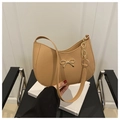 Details der goldenen Metallschleife und Textur der khakifarbenen Halbmond-Tasche - Khaki