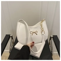 Detail der weißen Hobo-Tasche mit goldener Metallschleife und Kettenriemen - Weiß