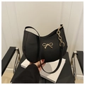 Detalle de bolso hobo negro con hebilla de lazo dorado y cadena decorativa lateral - Negro