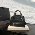 Classic black pebbled leather tote bag with gold hardware and top handle on white stand - Black