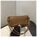 Detailed close-up of brown leather shoulder bag with decorative strap knot and gold logo - Brown