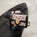 White mini square handbag with red strawberry print, black trim, and gold flower lock - Black