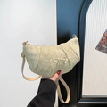 Chic beige woven crescent shoulder bag featuring a gold bow accent and leather strap - Khaki