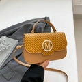 Brown patchwork crossbody bag with woven texture flap and golden M logo on grey blazer - Brown