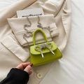 Lindgrüne Mini-Handtasche mit Strass-Schleife und Silberkette auf beige Sakko - Grün