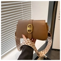Detail of a brown leather crossbody bag with vintage gold buckle and woven strap - Brown
