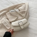 Elegante bolso de hombro beige con hebilla plateada y ojales sobre blazer vintage chic - Blanco