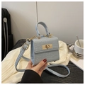 Dettaglio mini borsa azzurra con goffratura a coccodrillo e chiusura in metallo dorato - Blu