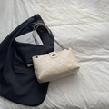 Borsa tote trapuntata beige con tracolla a catena e chiusura a girello su lenzuola bianche - Bianco Sporco