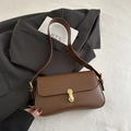 Brown leather underarm bag with curved bottom and golden oval hardware lock - Brown
