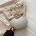 Borsa a sella grigio chiaro con trama perlata e manico dorato su sfondo neutro - Bianco
