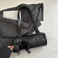 Chic black PU leather cylinder bag featuring a prominent bow and silver hardware detail - Black