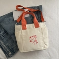 Cream canvas tote bag featuring orange handles and a cute red cartoon bear design - Orange Without Charm