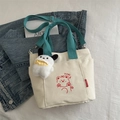 Off-white canvas tote bag with blue straps, bear graphic and a plush dog charm - Green with Charm