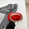 Modern red semicircular clutch with a large gold C-shaped metal handle and chain strap - Red