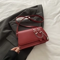 Rote Baguette-Tasche mit Silberkette und Metallschnallen auf grauem Blazer - Rot