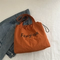 Fanyissa burnt orange canvas drawstring tote bag in a flat lay minimalist style - Orange