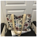 Dettaglio della borsa tote in tela floreale con trama intrecciata e manici in kaki - Beige