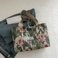 Tragetasche aus floralem Jacquard-Canvas mit rosa Blumen und beigen Trageriemen im Lifestyle - Grün