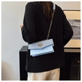 Close-up of light blue crossbody bag featuring a golden chain strap and M-logo clasp - Blue