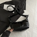 Glossy black half-moon crossbody bag with silver eyelets and minimalist褶皱 design - Black