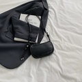 Black lychee texture leather underarm bag with knot strap on white artistic background - Black