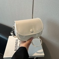 Elegante bolso bandolera color crema con textura de grano lichi y correa ajustable - Blanco