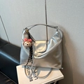 Macro detail of silver metallic hobo bag with Capnes logo and plush bear charm - Silver
