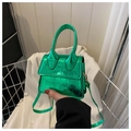 Mini sac à main vert à texture crocodile et fini métallique tenu par la poignée - Vert