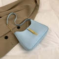 Sac hobo bleu clair en cuir PU avec chaîne dorée et boucle sur fond de tissu blanc - Bleu