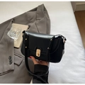 Details einer schwarzen Lackledertasche mit goldenem Drehverschluss und Nietenverzierung - Schwarz