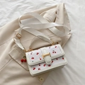 White crossbody square bag with red cherry pattern and gold metal clasp on fabric background - With Pendant / White