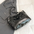 Minimalist black patent leather tote bag with a small golden bow and slim shoulder straps - Black