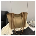 Detail van beige en bruine draagtas met lederen handvatten op een houten tafel - Khaki
