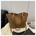 Gedetailleerde weergave van de bruine leren tote bag en dubbele riemen in lifestyle-setting - Bruin