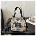 Detail of retro drawstring bucket tote bag with colorful butterfly embroidery and logo patch - Style 6