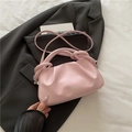 Bolso nube plisado rosa con asa anudada y correa bandolera sobre traje gris - Rosa