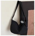 Detail of black nylon dumpling bag featuring a detachable coin purse and adjustable strap - Black