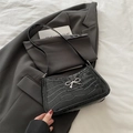 Schwarze Schultertasche mit Krokodilmuster und silberner Metallschleife - Schwarz