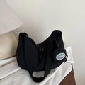 Sac bandoulière demi-lune en nylon noir minimaliste avec mini pochette ronde sur table en bois - Noir