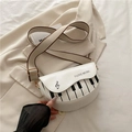 Witte zadeltas met piano toetsen print en I LOVE MUSIC tekst op een beige blazer - Wit