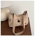 Macro detail of khaki nylon crossbody bag showing wrinkled texture and circular metal badge - Khaki